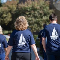 3 GVSU Alumni walking away from camera